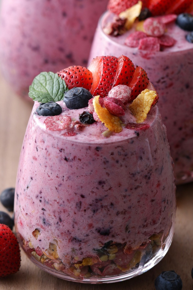 Сладкий десерт с ягодами в стаканах на столе