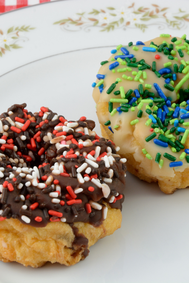 Сладкие пончики с глазурью на тарелке