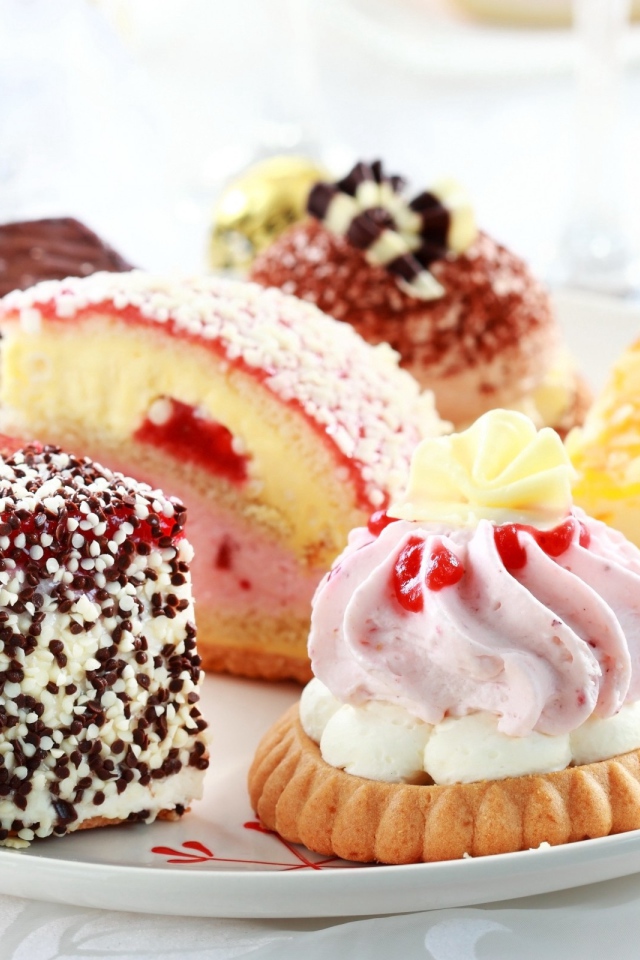 Сладкие вкусные разные пирожные на тарелке