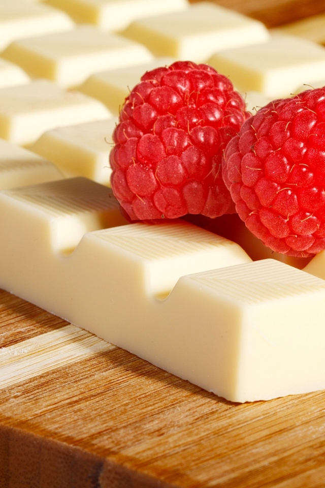 Сладкий белый шоколад с ягодами малины на столе