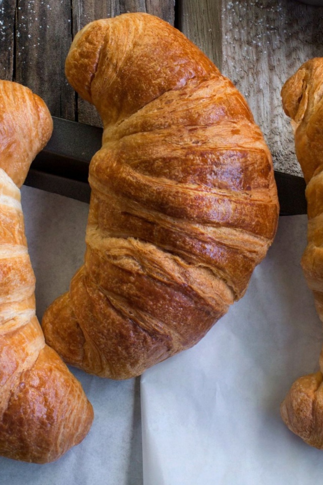 Три свежих круассана на столе с кремом 