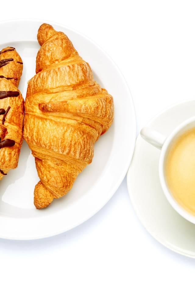 Два круассана с чашкой кофе на белом фоне