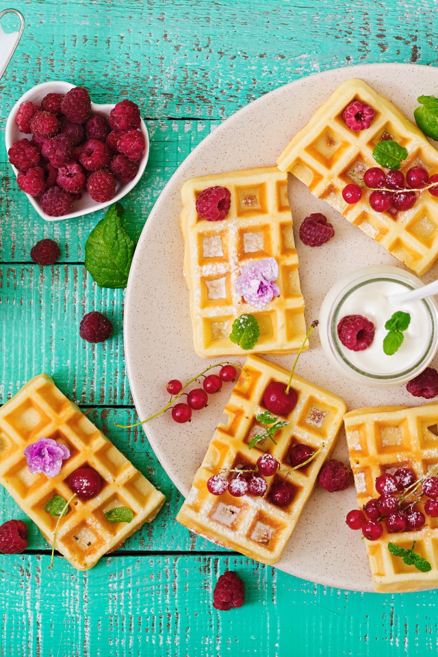 Вафли с малиной и красной смородиной на тарелке