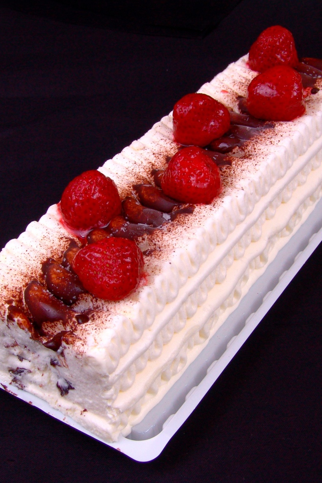 Белый торт с клубникой на черном фоне