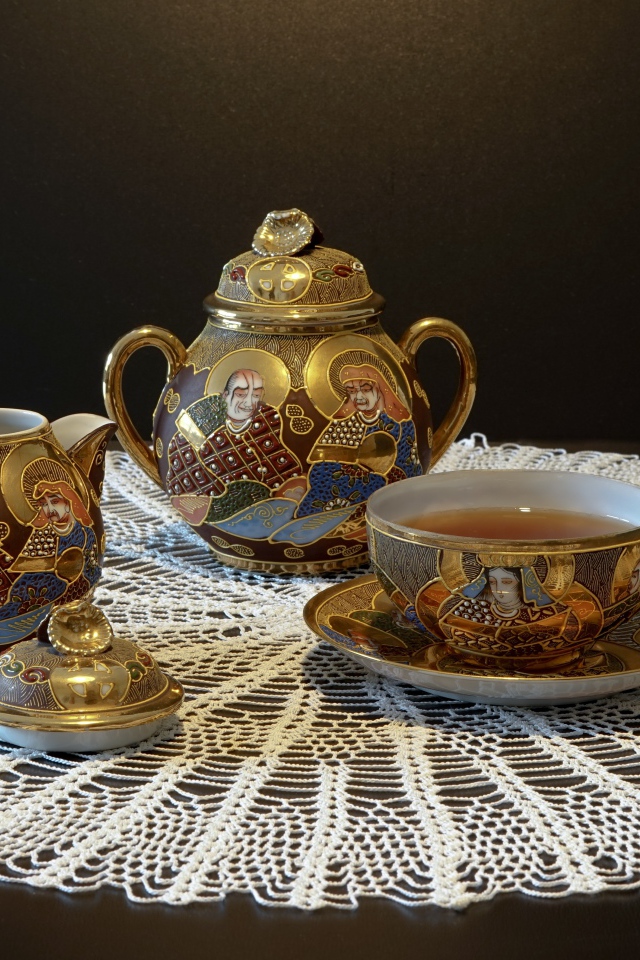 Красивый чайный сервиз на столе с белой салфеткой