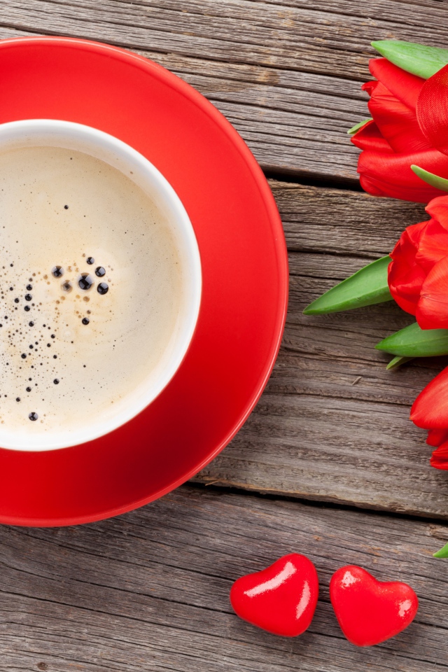 Чашка кофе с красными тюльпанами на деревянном столе 