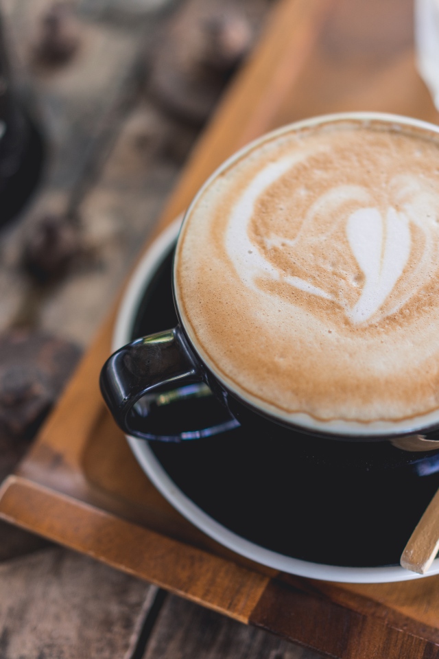 Большая чашка кофе с пеной на столе