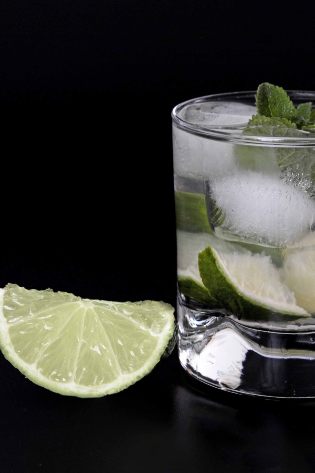 Коктейль кайпиринья на черном фоне с кусочком лайма