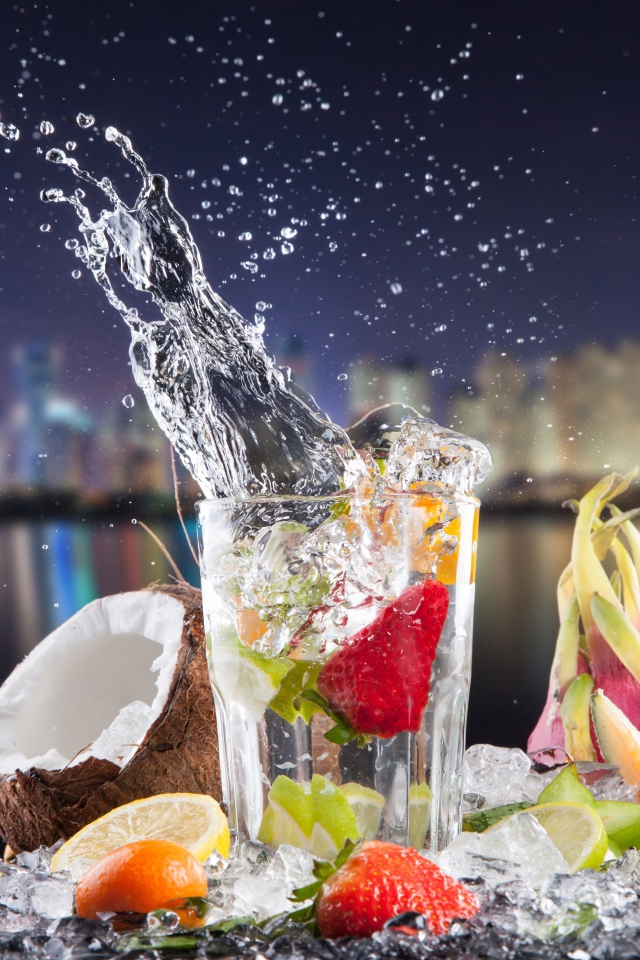 Напиток в стакане с тропическими фруктами на фоне ночного города