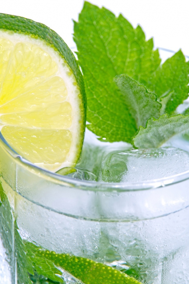 Стакан с освежающим напитком с мятой и лаймом на белом фоне