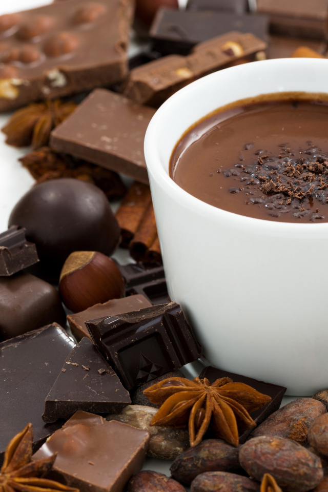 Горячий шоколад в белой чашке на столе с орехами
