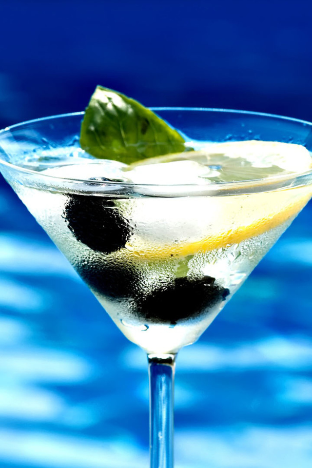 Мартини в бокале с лимоном и оливками 