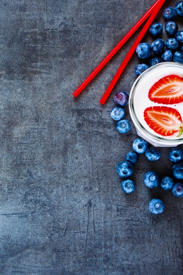 Молочный коктейль с клубникой и черникой на столе 