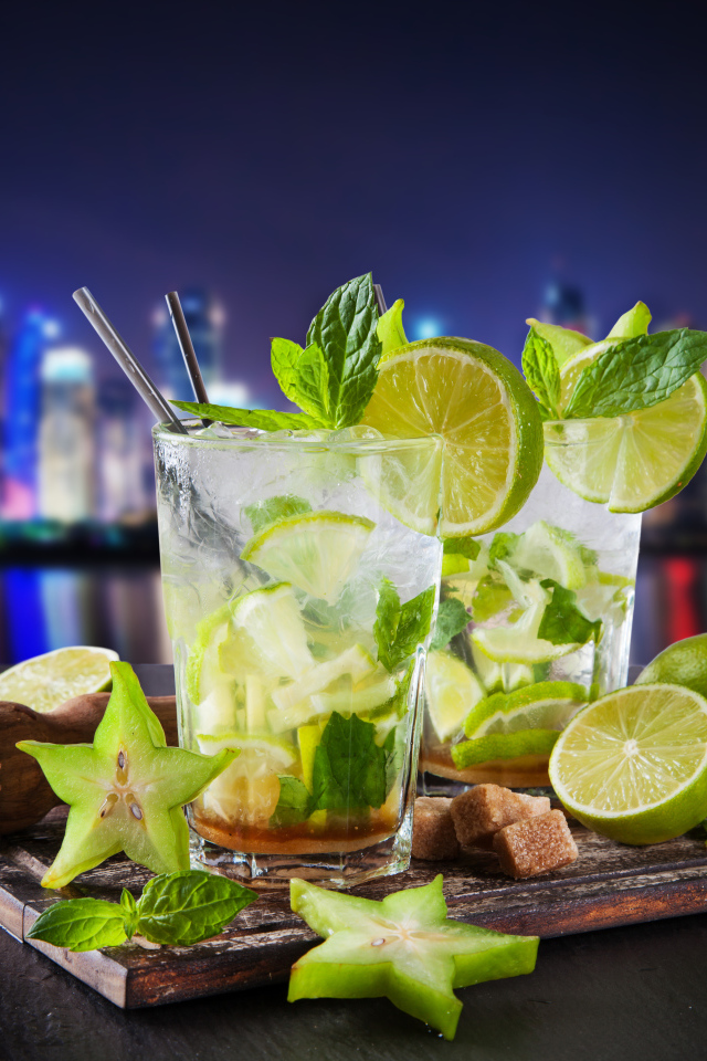 Коктейль мохито с лаймом и карамболью на фоне города