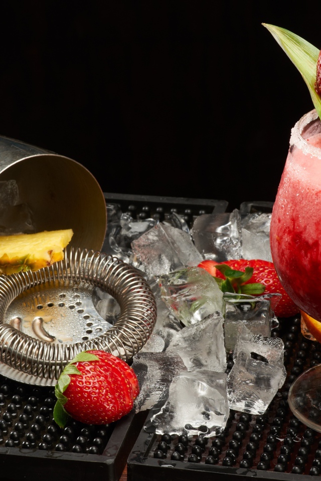 Тропический коктейль в бокале на столе со льдом