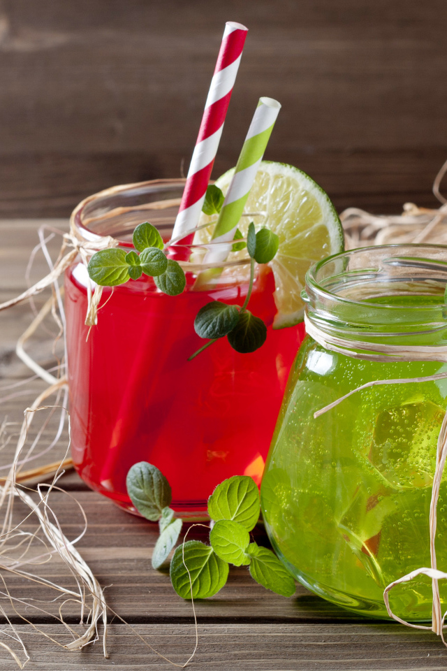 Две банки с коктейлями на деревянном столе с соломой