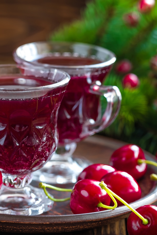 Две чашки вишневого сока со свежими вишнями на столе