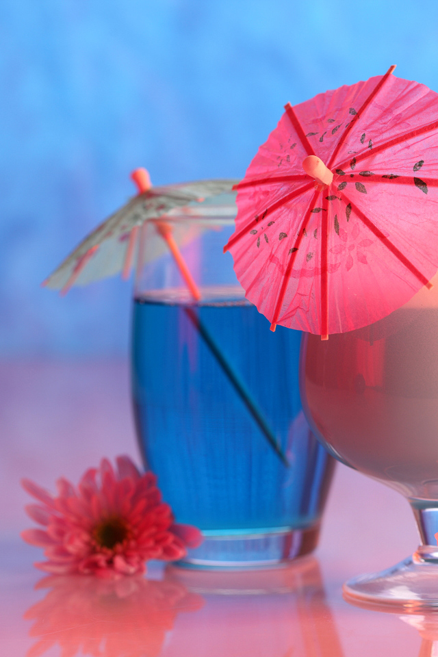 Два бокала с коктейлем на столе с розовыми цветами хризантемы