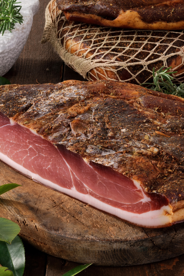 Кусок копченого мяса со специями на разделочной доске