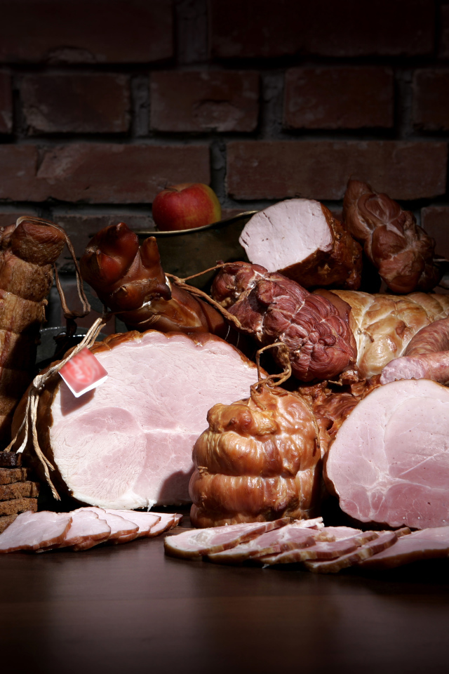 Аппетитные мясные продукты на фоне кирпичной стены 