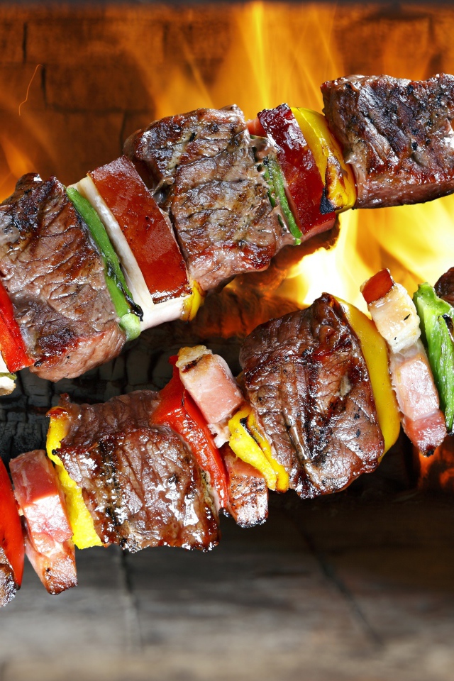 Аппетитный шашлык с овощами на фоне огня