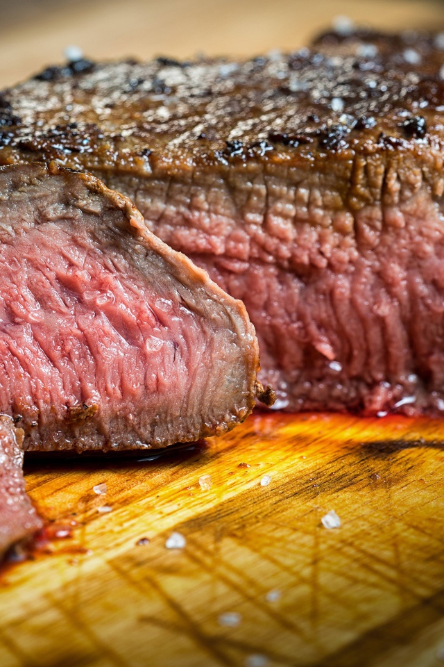 Аппетитный нарезанный кусок мяса на разделочной доске