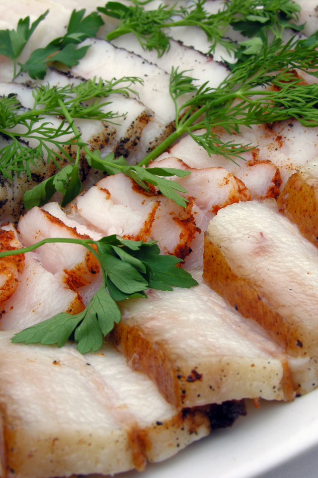 Аппетитное нарезанное копченое сало с зеленью 