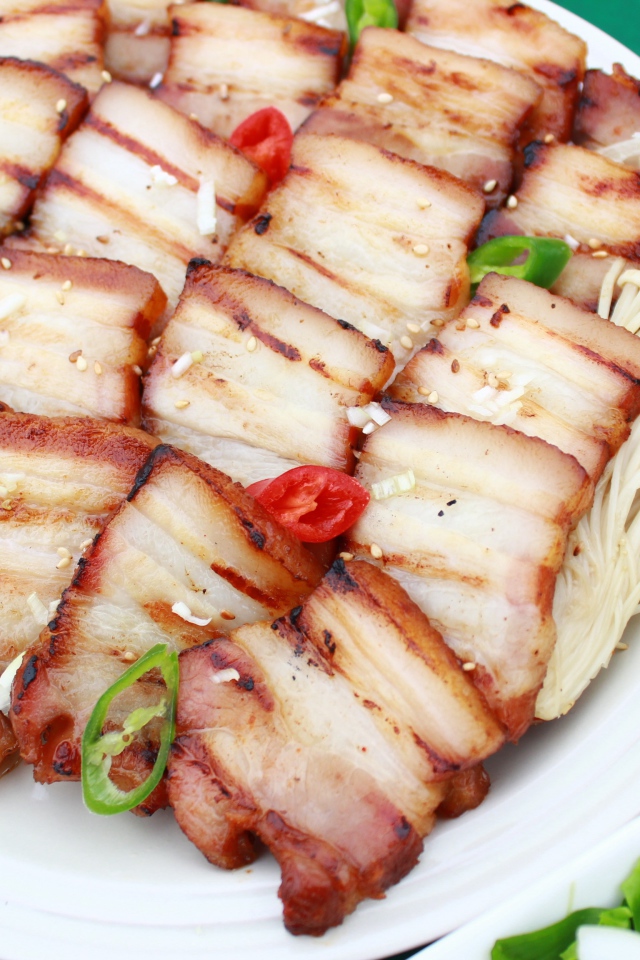 Аппетитное копченое сало на столе с овощами