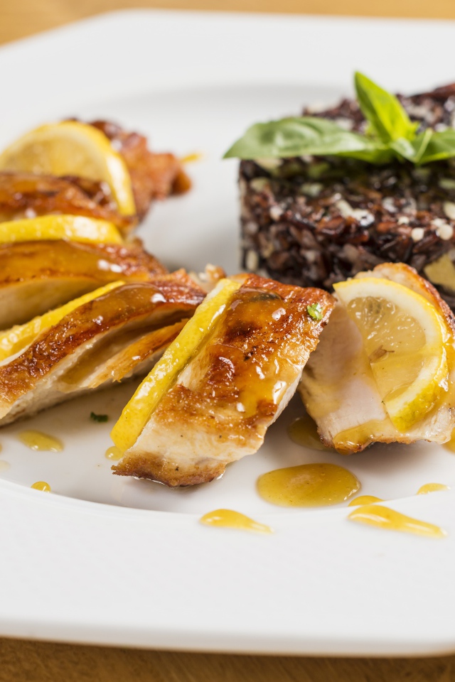 Куриный рулет на белой тарелке с рисом