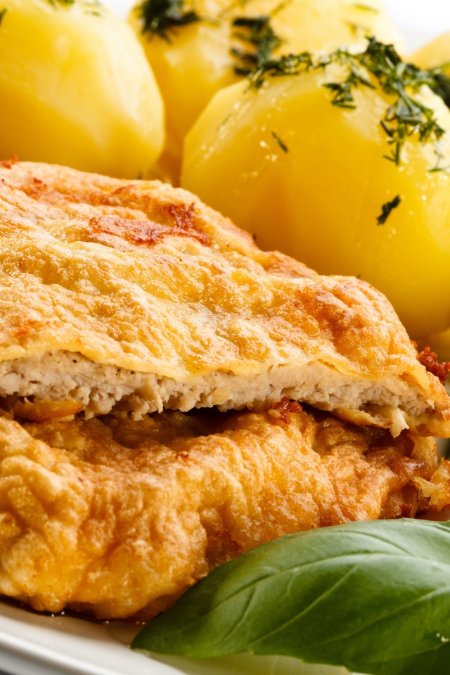 Отбивная на тарелке с вареным картофелем и салатом