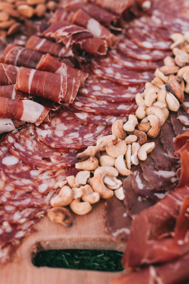 Мясная нарезка с орехами на разделочной доске