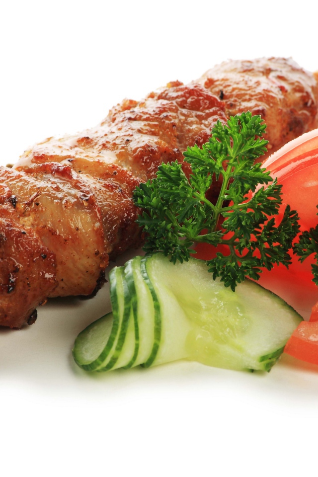 Шашлык с огурцами, помидорами и зеленью на белом фоне