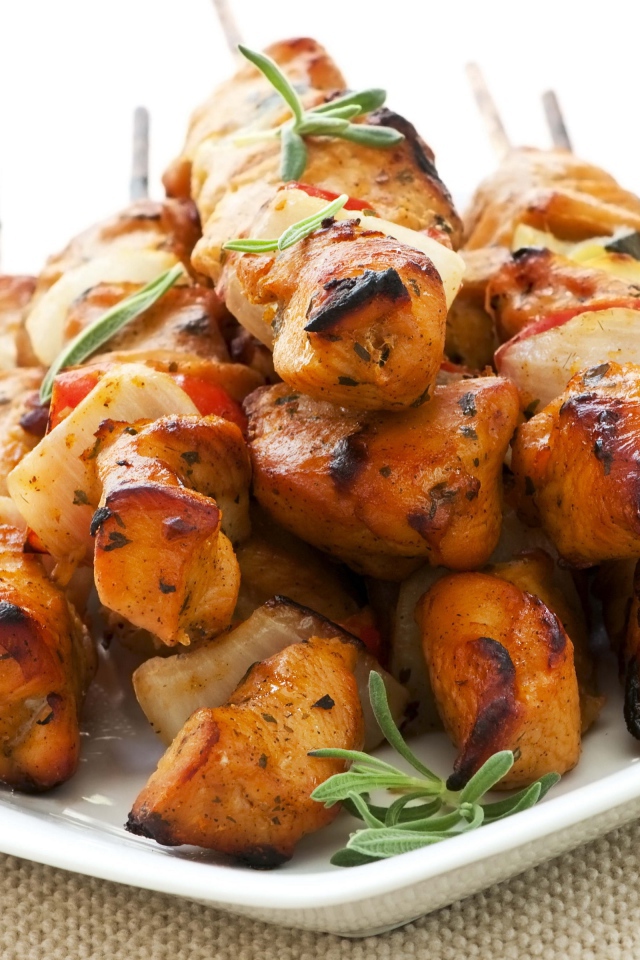 Шашлыки на белой тарелке с зеленью розмарина