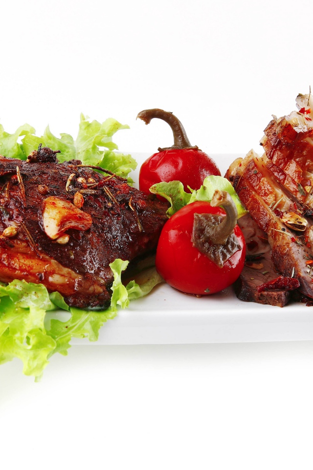 Мясо с листьями салата и красным перцем на белом фоне