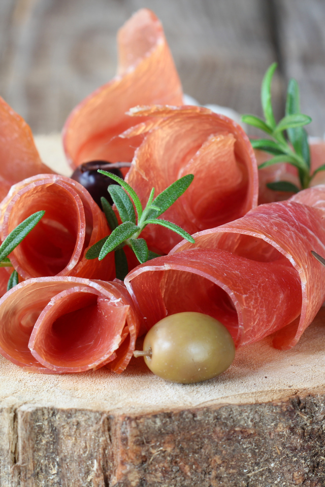 Прошутто  с оливками на деревянном столе 