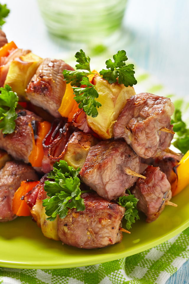 Шашлык с овощами на тарелке на столе