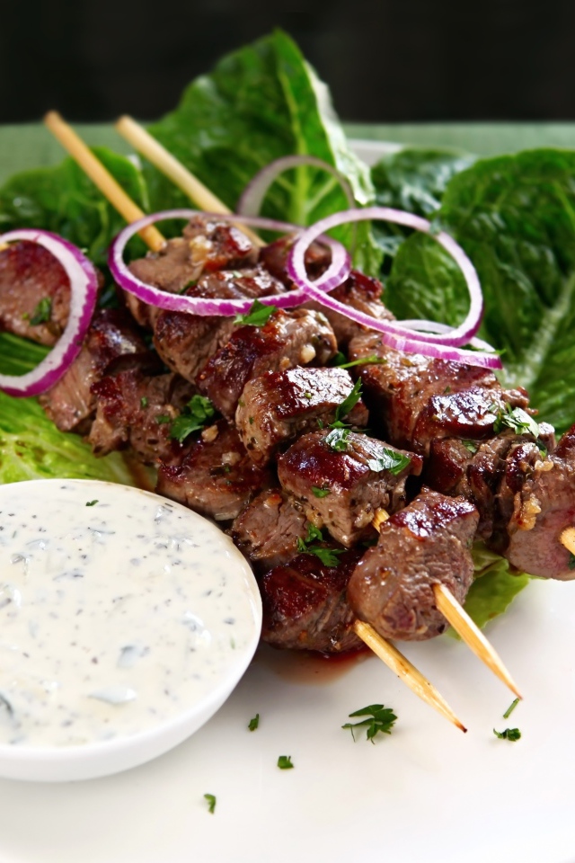 Вкусный шашлык на деревянных шампурах с соусом