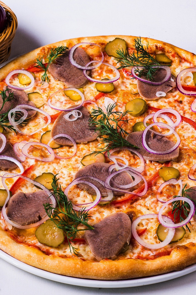 Вкусная пицца с солеными огурцами, языком и луком на столе с овощами