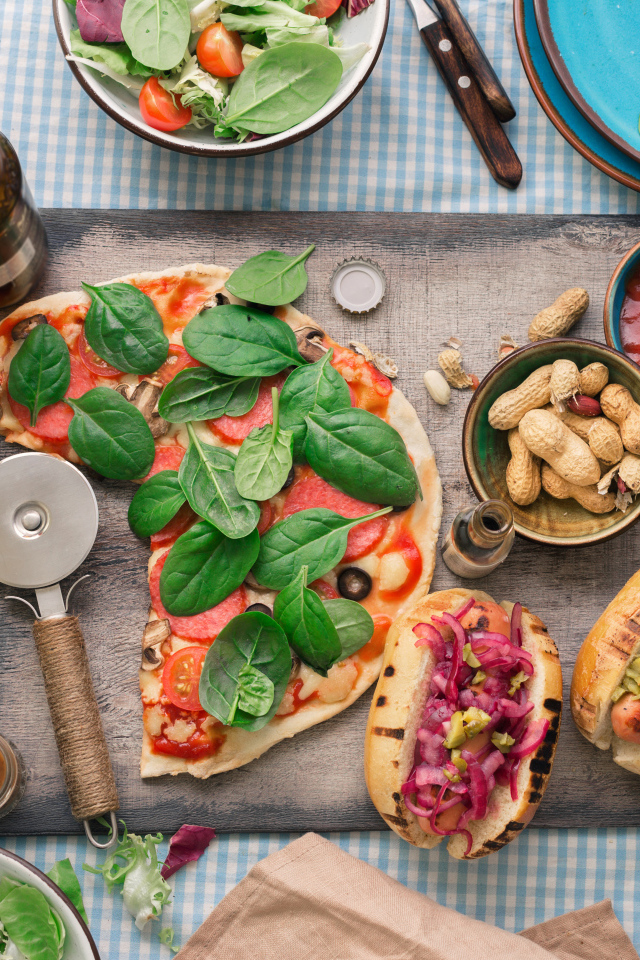 Пицца с хотдогами на столе с соусом