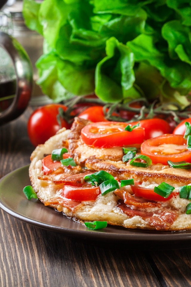 Пицца с помидорами на столе с чаем и зеленью 