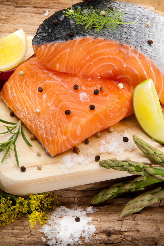 Филе красной рыбой на столе со спаржей и лаймом