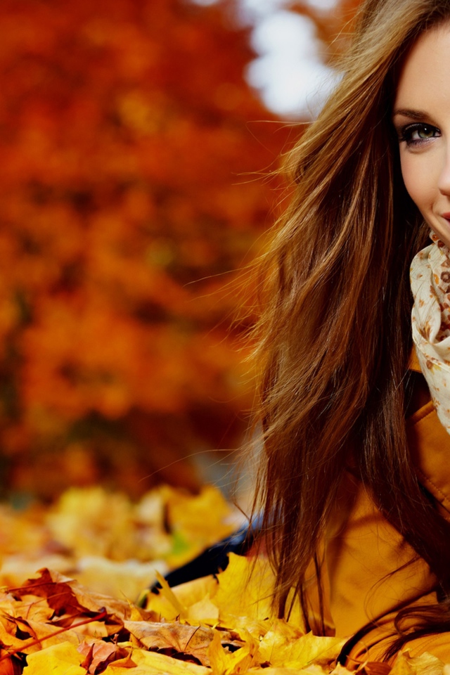 Красивая девушка лежит на опавших осенних листьях