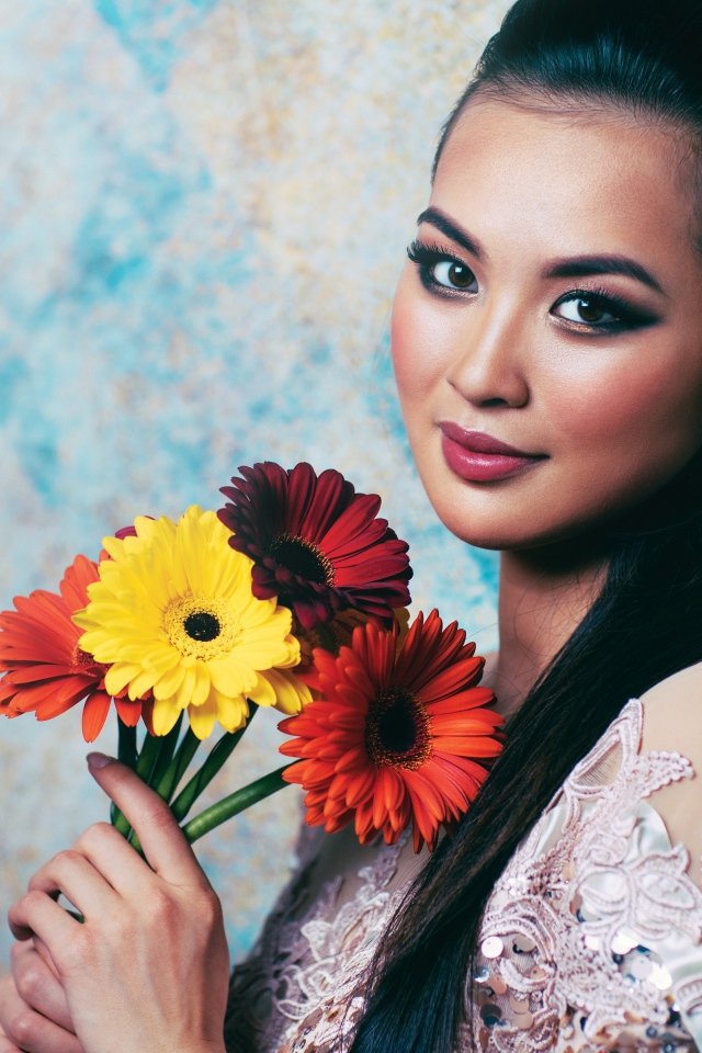 Красивая девушка азиатка с букетом гербер в руках