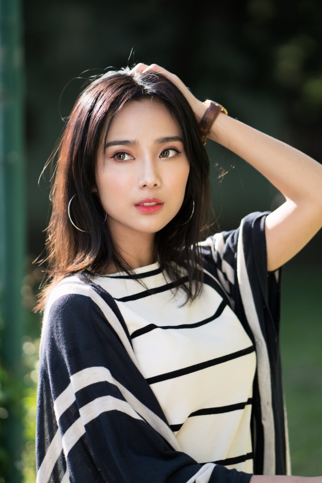 Красивая девушка азиатка с часами на руке 