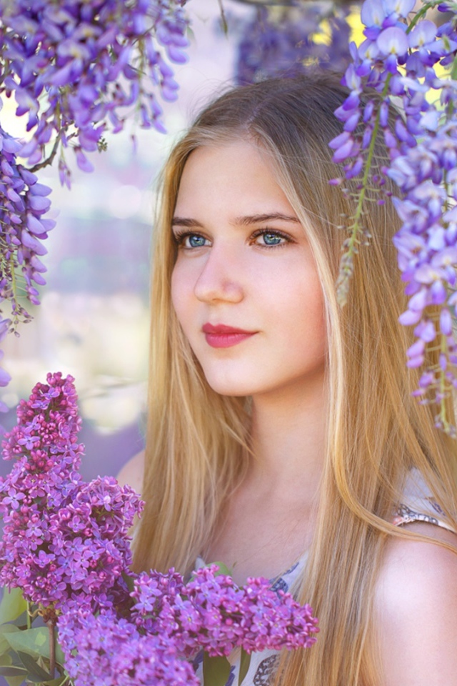 Красивая блондинка с букетом сирени на фоне цветов глицинии