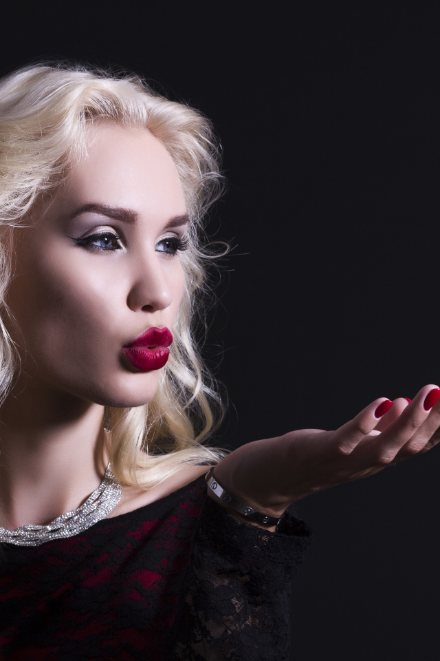 Красивая голубоглазая блондинка с красными губами в черном платье