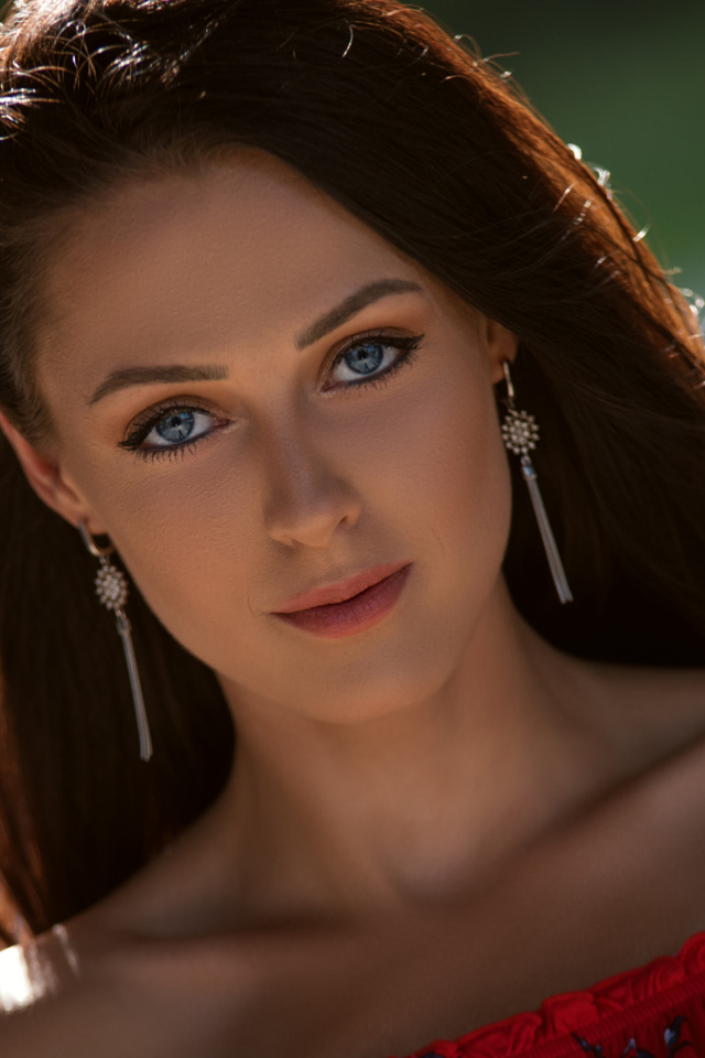Красивая голубоглазая брюнетка с серьгами у ушах