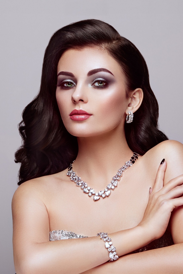 Красивая яркая брюнетка на сером фоне