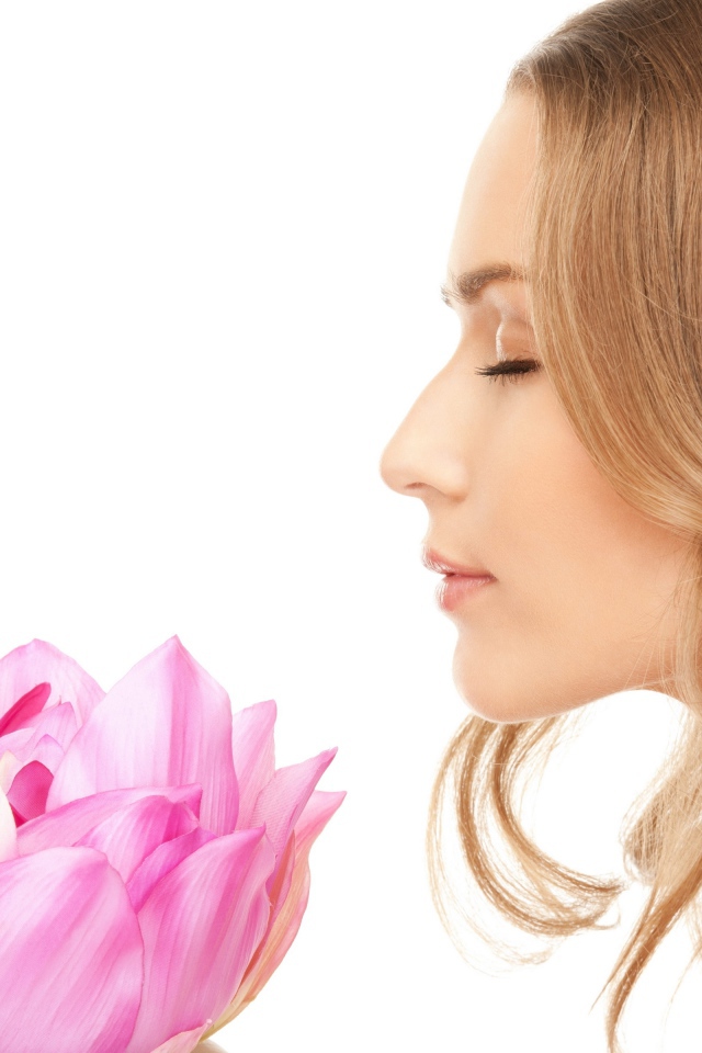 Красивая девушка шатенка наслаждается ароматом лотоса 