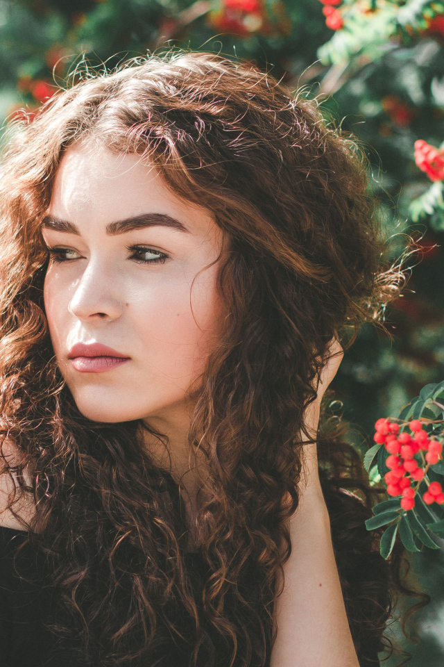 Красивая шатенка у ветки с красными ягодами рябины